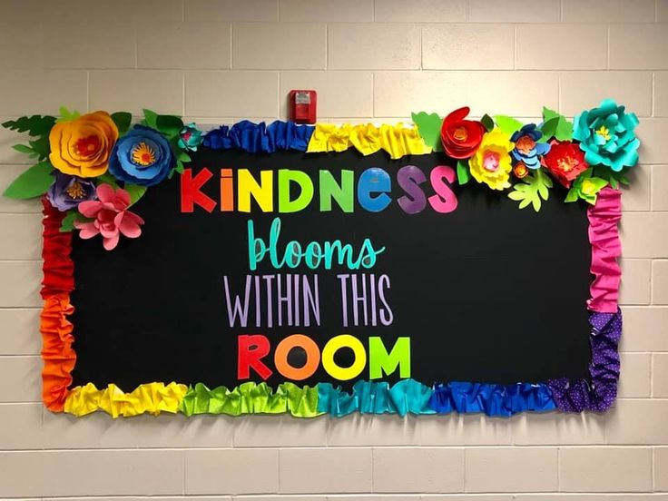 a sign that says kindness blooms within this room with colorful flowers on the blackboard