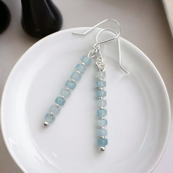 "Looking for a gift for a March birthday? Beautiful blue Aquamarine Earrings. Long, elegant aquamarine earrings dangle gracefully from a twinkling silver setting. These make a perfect gift and are automatically sent is a gift ready box with a polishing cloth. * Sterling Silver * Approximately 2\" long * Genuine Aquamarine Heishi Gemstone Beads * Sent in a Ribboned Gift Box with Polishing Cloth * Handmade in Montana  ----- OUR MATERIALS -----  *STERLING SILVER - Experience the elegance of Sterlin Elegant Birthstone Earrings For Birthday, Handmade Elegant Aquamarine Earrings, Elegant Aquamarine Earrings With Ear Wire, Elegant Aquamarine Nickel-free Earrings, Handmade Aquamarine Drop Earrings, Aquamarine Earrings Gift, Light Blue Aquamarine Drop Earrings, Light Blue Crystal Drop Earrings For Gift, Light Blue Crystal Earrings For Gift