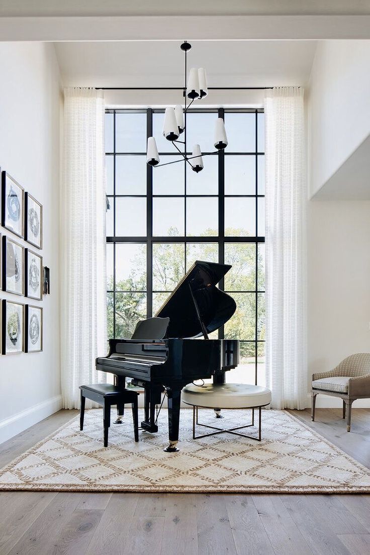 a grand piano in front of a large window