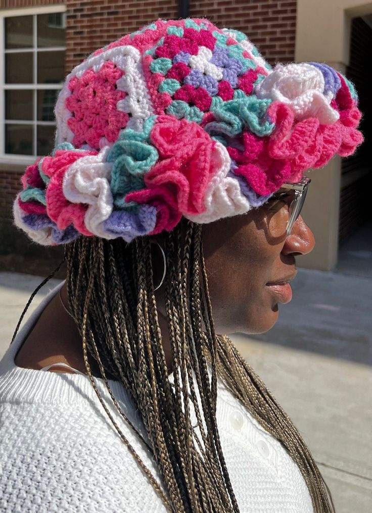 a woman with dreadlocks wearing a crocheted hat