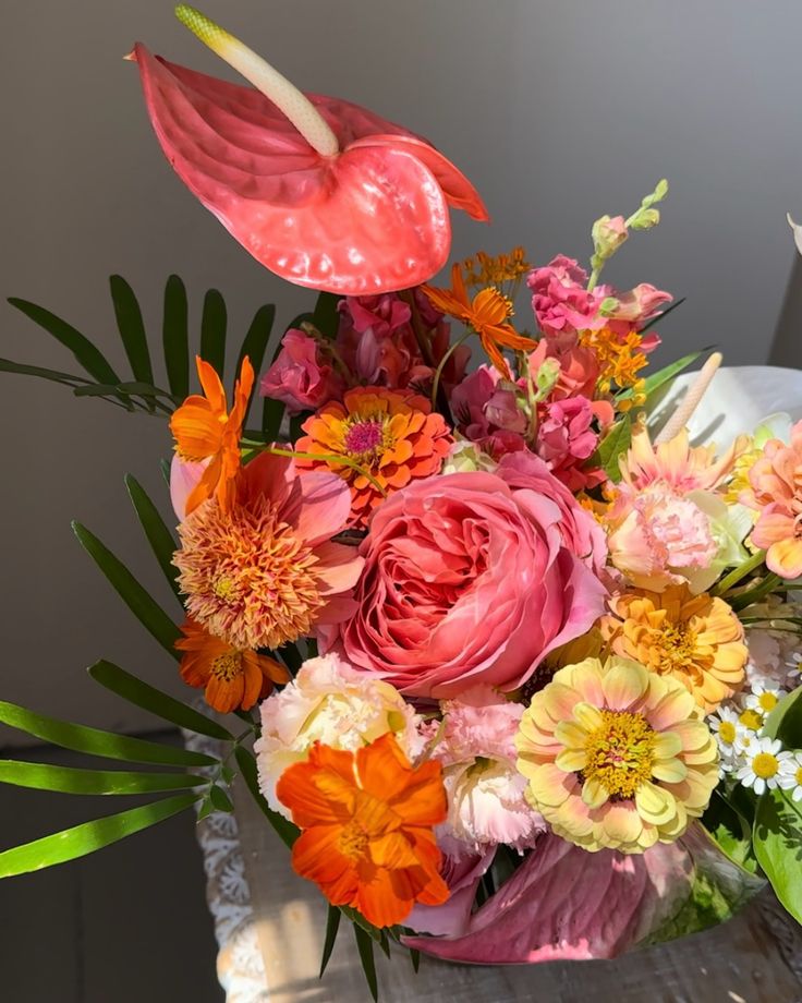 a vase filled with lots of flowers on top of a table