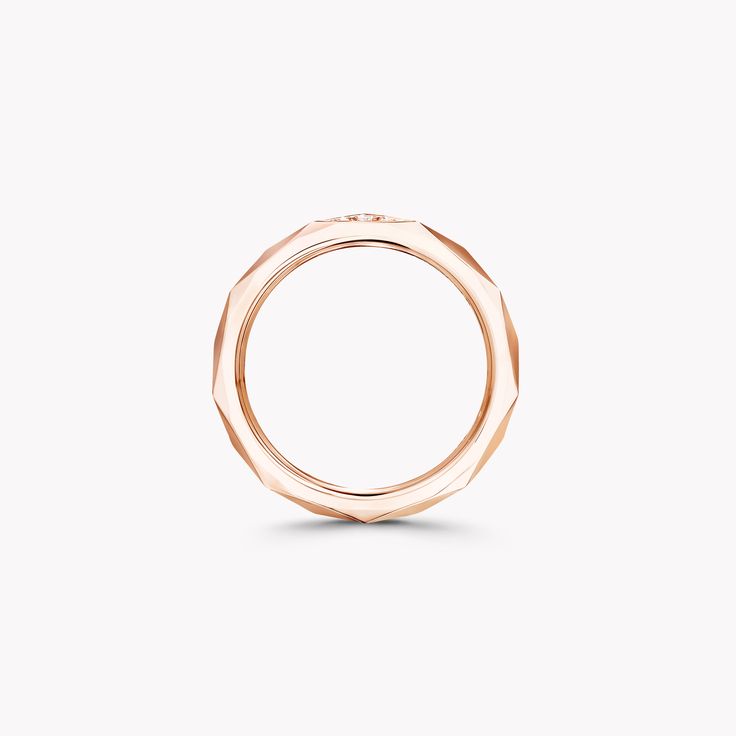 a rose gold ring on a white background