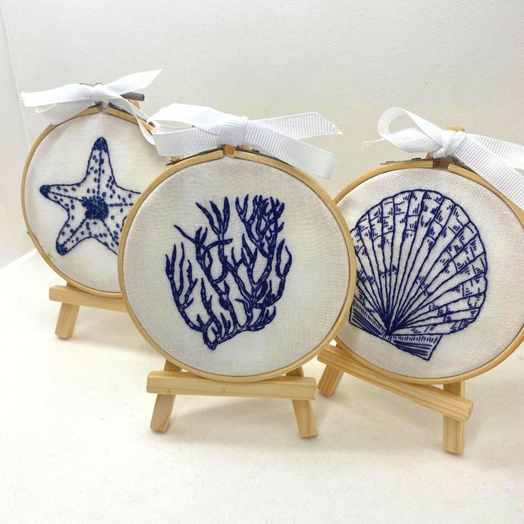 three embroidery kits with seashells and starfish on them