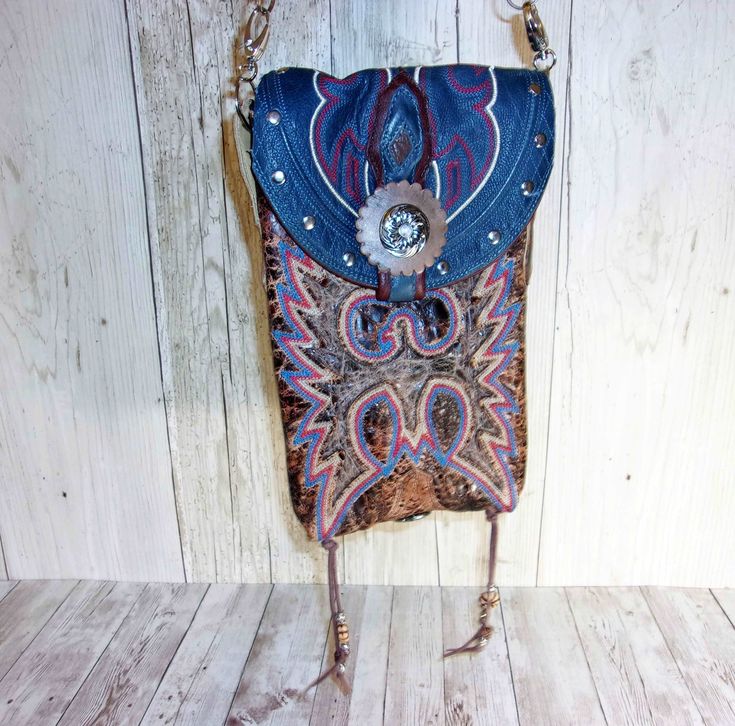 This crossbody hipster bag is the ultimate in sustainable style and beautifully blends rustic charm with western sophistication. It is the mid-size and most popular of our collections. Handmade from recycled cowboy boots Western-chic details and accents Removable crossbody strap for hipster-style wearing Magnetic snap closure to keep your essentials secure Each purse is signed and numbered by the artist. No two alike! Measuring approximately 7"x9" with 48" strap. Saddle up and get ready to make Western Style Crossbody Bags For Western-themed Events, Western Style Bags For Festivals, Western Crossbody Purse, Boot Purse, Totes Boots, Cowboy Boot Purse, Hipster Purse, Hipster Bag, Fringe Handbags