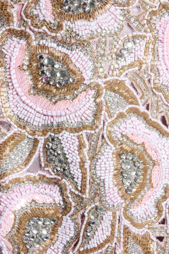 pink and gold beaded fabric with large flowers on the side, close up view