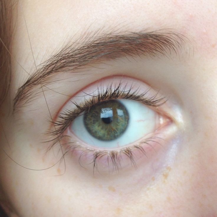 a close up of a person's eye with brown hair