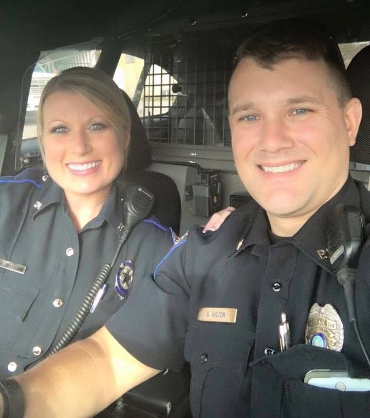 two police officers are smiling for the camera