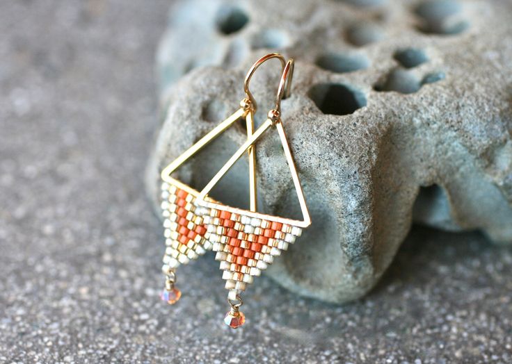 "Beautiful geometric beaded earrings made with gold, champagne and rust colored Miyuki seed beads. Gorgeous Swarovski crystal drops wire wrapped in 14KT gold fill wire. These earrings are perfect to add sparkle and color to any outfit. Well made and stylish! Earring length:1 3/4\" Tringle size: 3/4\" Swarovski crystal size: 3mm Earring wires: 14KT Gold Fill *Petite style earrings Please note that pictures are taken up close to show detail. Therefore, these earrings look larger in the pictures th Triangle Beaded Earrings, Seed Beaded Earrings, Jewelry 2023, Stitch Earrings, Hanging Necklaces, Brick Stitch Earrings, Petite Style, Gold Champagne, Earring Wires