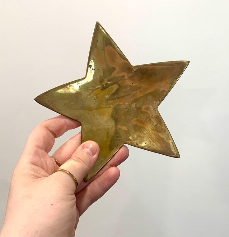 a hand holding a gold star shaped object