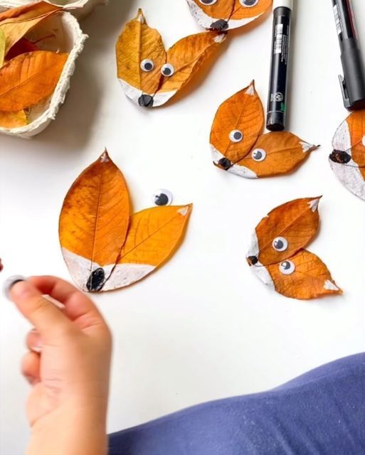 someone is making paper foxes out of leaves and crayon pens on the table