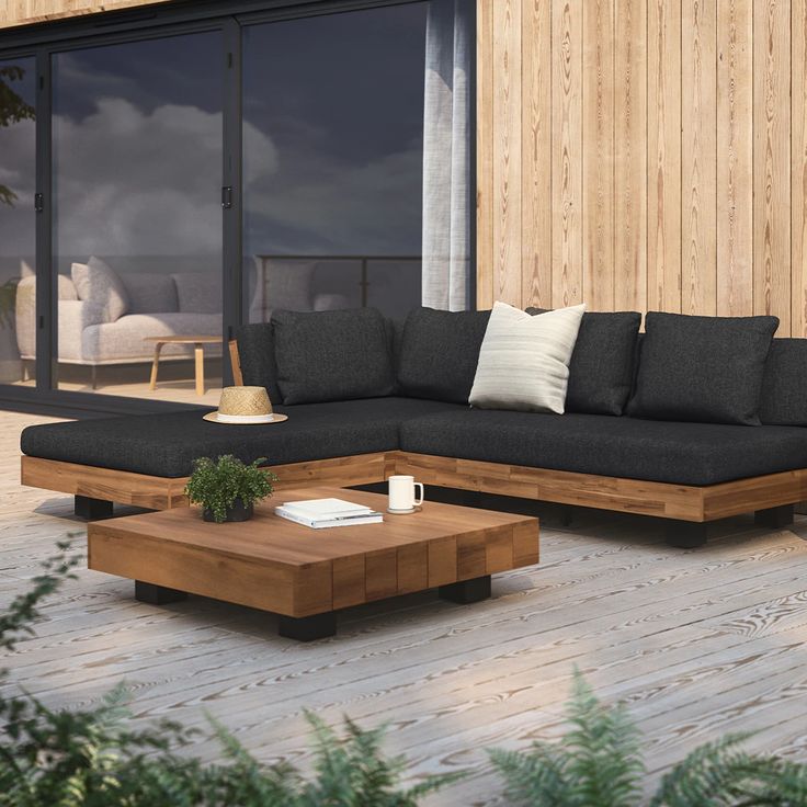 a couch sitting on top of a wooden floor next to a table with a coffee cup