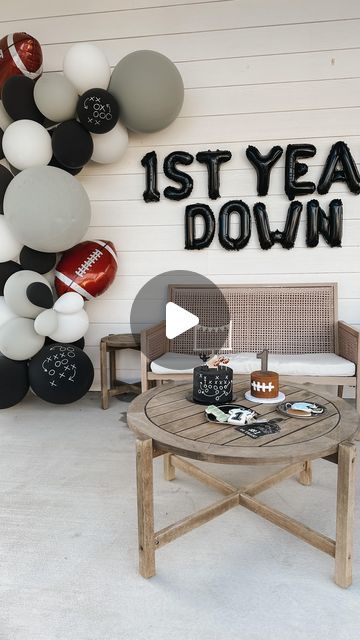 a football themed room with balloons and decorations on the wall, along with a coffee table that says it's year down