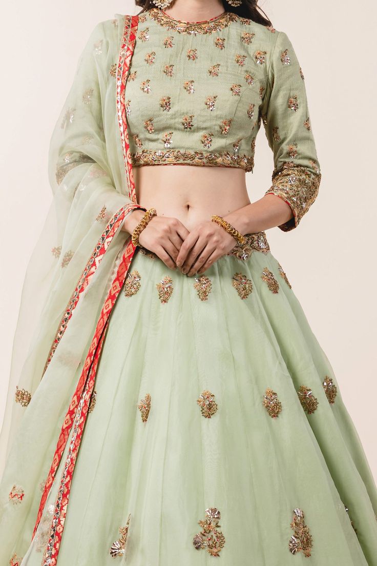 Pastel green lehenga with attached cancan, all-over floral zardozi embroidery and sequin embellishments. Comes with padded blouse and dupatta.
Component: 3
Embroidered
Neckline: Round
Sleeve Length: Three Quarter
Fabric: Lehenga and Dupatta: Organza; Blouse: Banarasi
Color: Green
Dori, mukaish, pearls, zardozi and resham embroidery
Embroidered blouse and dupatta
Cutout at the back - Aza Fashions Green Organza Lehenga, Designing Clothes, Blouse Yoke, Lehenga Dupatta, Highlights Color, Organza Lehenga, Zardozi Embroidery, Organza Blouse, Making Clothes