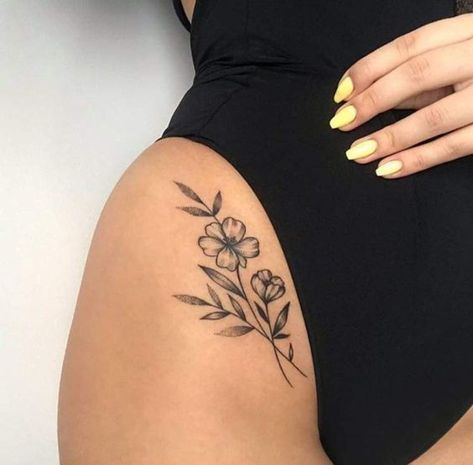 a woman in a black swimsuit with flowers tattooed on her thigh and the bottom half of her body