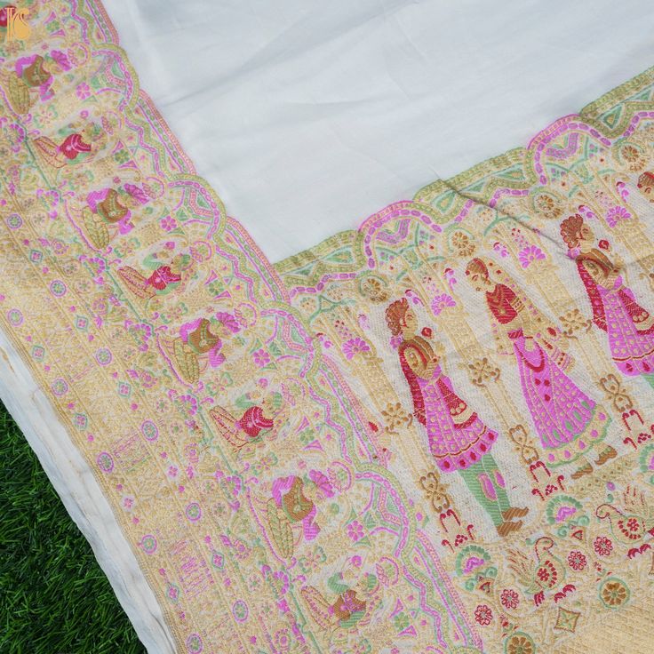 an embroidered cloth is laying on the grass