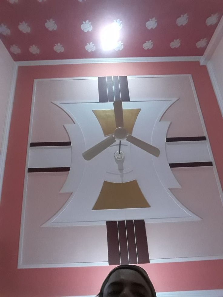 the ceiling is painted pink and white with flowers on it, along with a clock