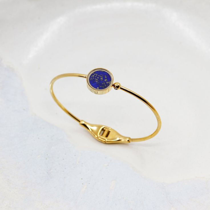 Lapis Lazuli d'Afghanistan, pierre précieuse de la royauté &, de la spiritualité, favorisant calme et communication
Pierre brute semi-précieuse sélectionnée de manière éthique, taillée et polie à la main avec savoir-faire
Monture unique en verre protégeant la pierre contre les chocs, chutes, coups, rayures, l'eau, et la chaleur
Délicat zircon minutieusement serti sur la sphère élégante du bracelet
Bracelet en acier inoxydable 316
Bracelet plaqué sur de l'acier inoxydable 316

TAILLE DU BRACELET Luxury Blue Gemstone Bangle, Celestial Style Yellow Gold Bracelet, Adjustable Luxury Gold Bracelet With Gemstones, Celestial Style Bracelet Jewelry As Gift, Yellow Gold Celestial Bracelet Gift, Celestial Style Bracelet Jewelry For Gifts, Celestial Style Bracelet Jewelry Gift, Celestial Yellow Gold Bracelet Gift, Luxury Sapphire Jewelry In Lapis Lazuli