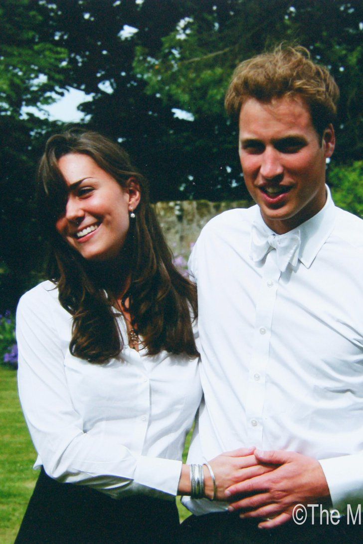 a man and woman standing next to each other in front of some trees on a sunny day