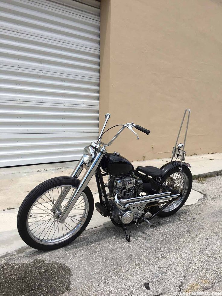 a black motorcycle parked in front of a garage door