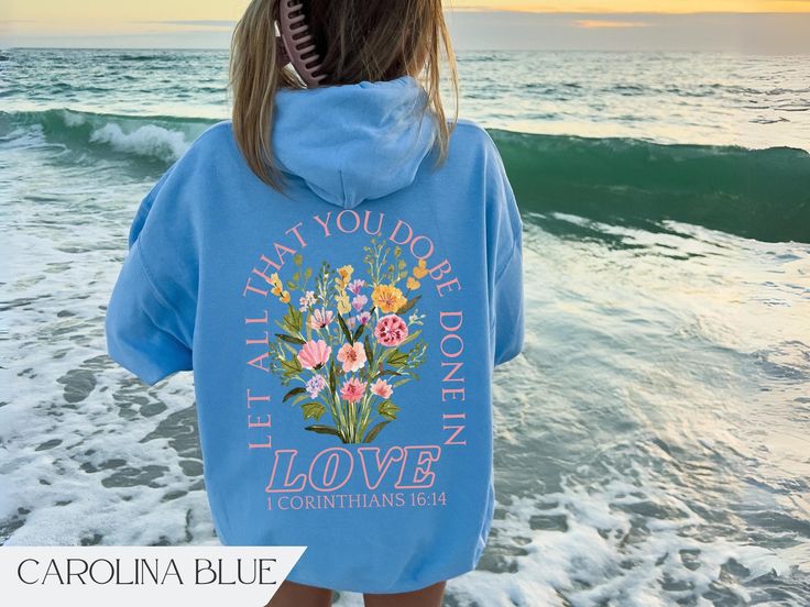 Trendy oversized Christian merch hoodie with Bible verse text and boho floral graphic on the back.  Graphic is made using direct to garment printing so you'll never have to worry about cracking or peeling images.  Available in Sand, White, Carolina Blue & Pink. Graphic is printed on the back. Unisex Gildan 18500 hoodie. Fits true to size. Size up for an oversized look.  - The tear-away label  - Made with a medium-heavy fabric blend of 50% cotton and 50% polyester - Fabric blends: Heather Sport c Bible Verse Hoodies, Cute Christian Sweatshirts, Bible Hoodies, Bible Merch, Trending Sweatshirts, Jesus Merch, Jesus Hoodies, Christian Sweatshirts, Christian Sweaters