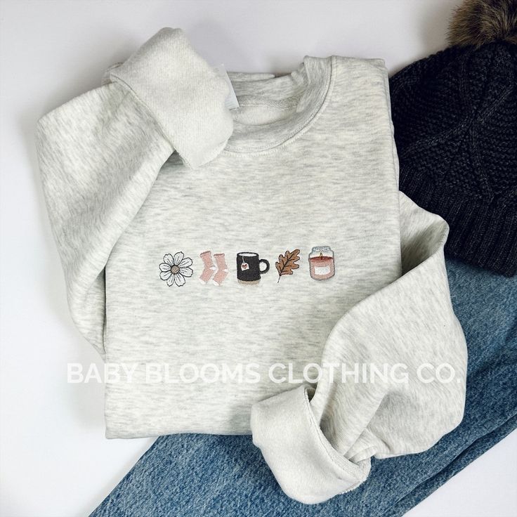 Inspired by hygge lifestyle, this sweatshirt embodies all the cozy fall things we love and think of when the seasons change: autumn flowers, fuzzy socks, warm cups of tea, colorful leaves and glowing candles.  This original design is embroidered onto a ultra-soft Lane Seven Premium Fleece Crewneck in Heathered Oatmeal, featuring a 80% cotton/20% polyester blend.  All sales final as these are made to order :) Hygge Autumn, Formal Winter Outfits, Fall Crewneck Sweatshirt, Hygge Lifestyle, Fall Things, Cute Shirt Designs, Embroidery Sweatshirt, Cozy Vibes, Simple Trendy Outfits