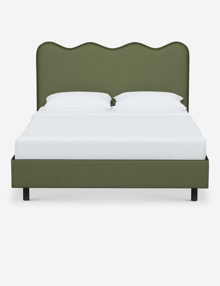 a bed with an upholstered headboard and foot board in green linens