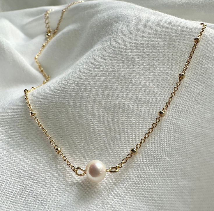 Elevate your style with our exquisite pearl necklace, a timeless piece that effortlessly combines classic elegance with a contemporary twist. Handcrafted with precision and attention to detail, this necklace is a stunning addition to your jewelry collection and a perfect choice for both everyday wear and special occasions. 🐚✨ Note: As each pearl is unique, slight variations in size, shape, and color may occur, ensuring that your necklace is truly one-of-a-kind. Finish: Gold Dipped Adjustable Ch Classic Pearl Clavicle Chain Necklace, Minimalist Pearl Pendant Jewelry With Round Beads, Dainty Everyday Pearl Chain Necklace, Classic White Pearl Drop Chain Necklace, Classic Pearl Necklaces With Delicate Chain, Classic Pearl Chain Necklace With Pearl Pendant, Minimalist Pearl Chain Necklace With Round Beads, Dainty Pearl Drop Chain Necklace For Everyday, Dainty Pearl White Chain Necklace With Pearl Charm