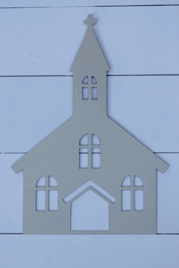 a metal cutout of a church with a clock on the front and side of it