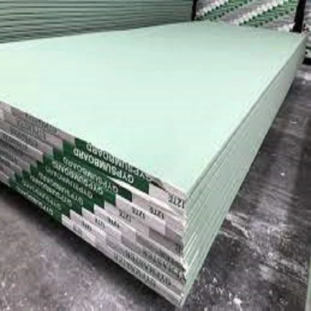 several stacks of green colored sheets stacked on top of each other in a warehouse area