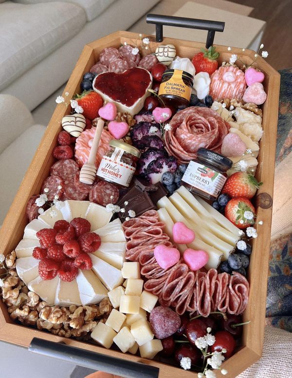 a wooden tray filled with lots of different types of food and confection items