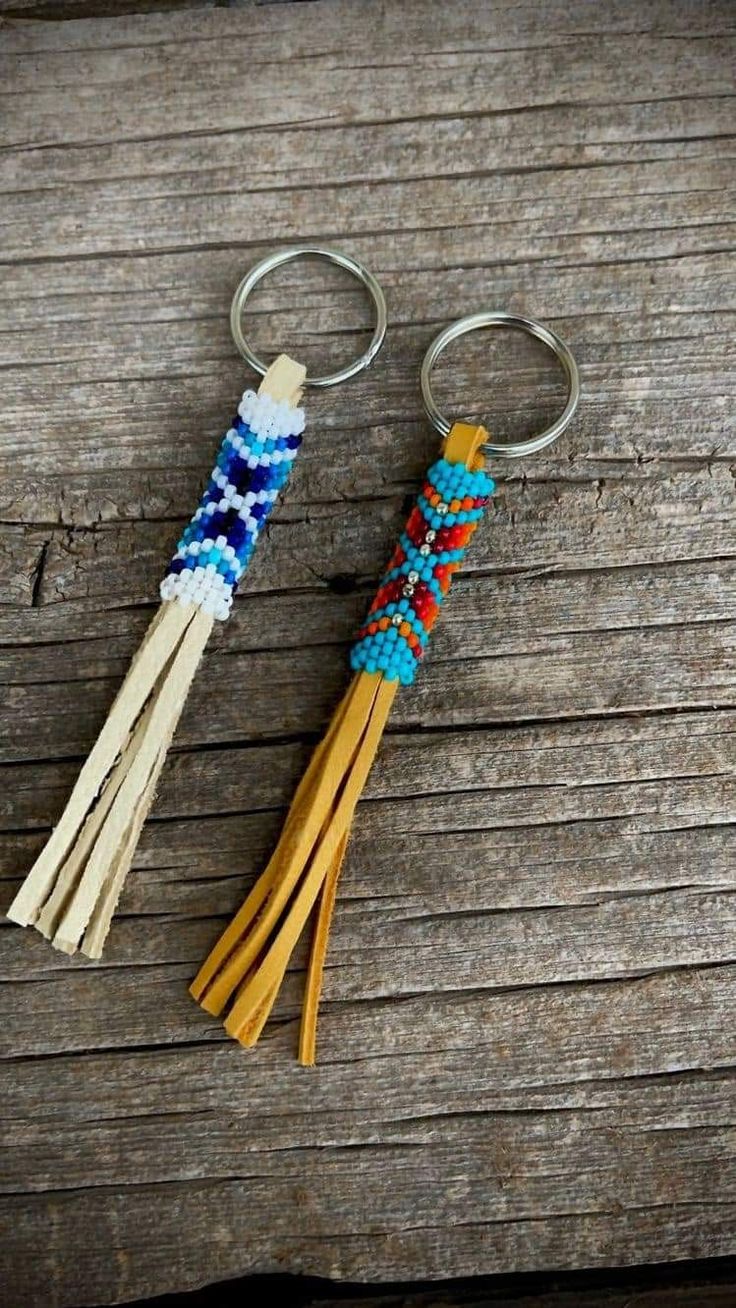 two tasseled key chains sitting on top of a wooden table