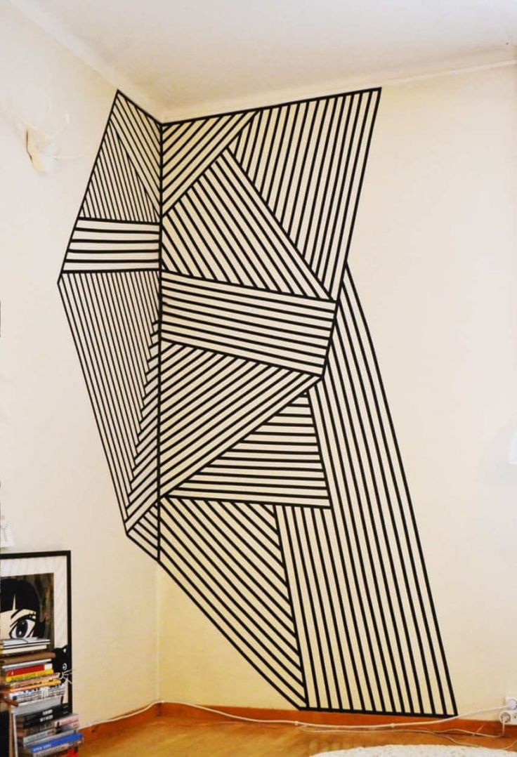 a room with a large black and white painting on the wall next to a bookshelf