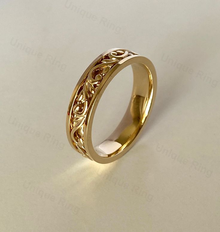 a gold wedding ring with filigrees on it