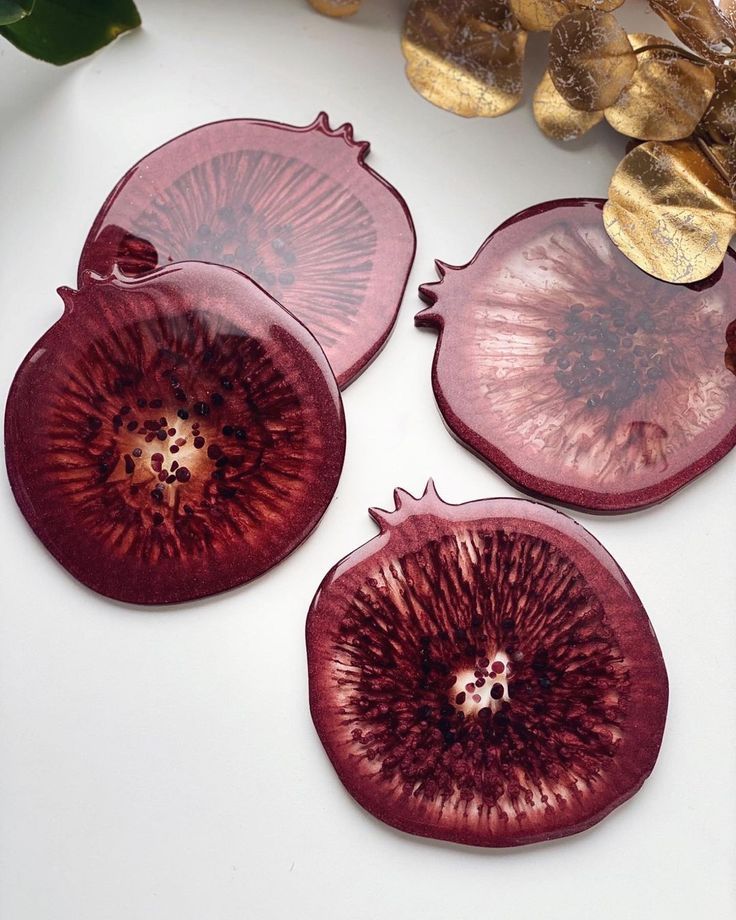 three pieces of red onion sitting on top of a white table next to a plant