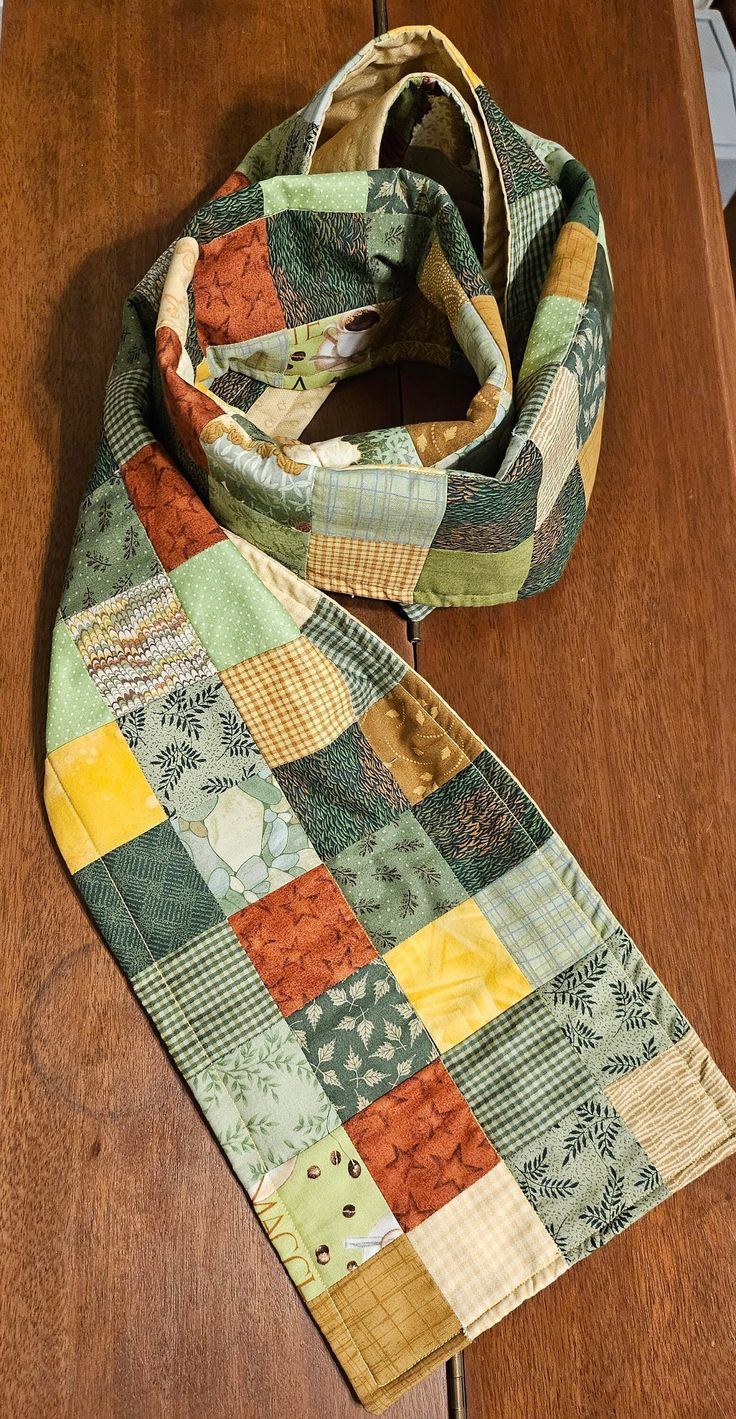 a multicolored scarf sitting on top of a wooden table