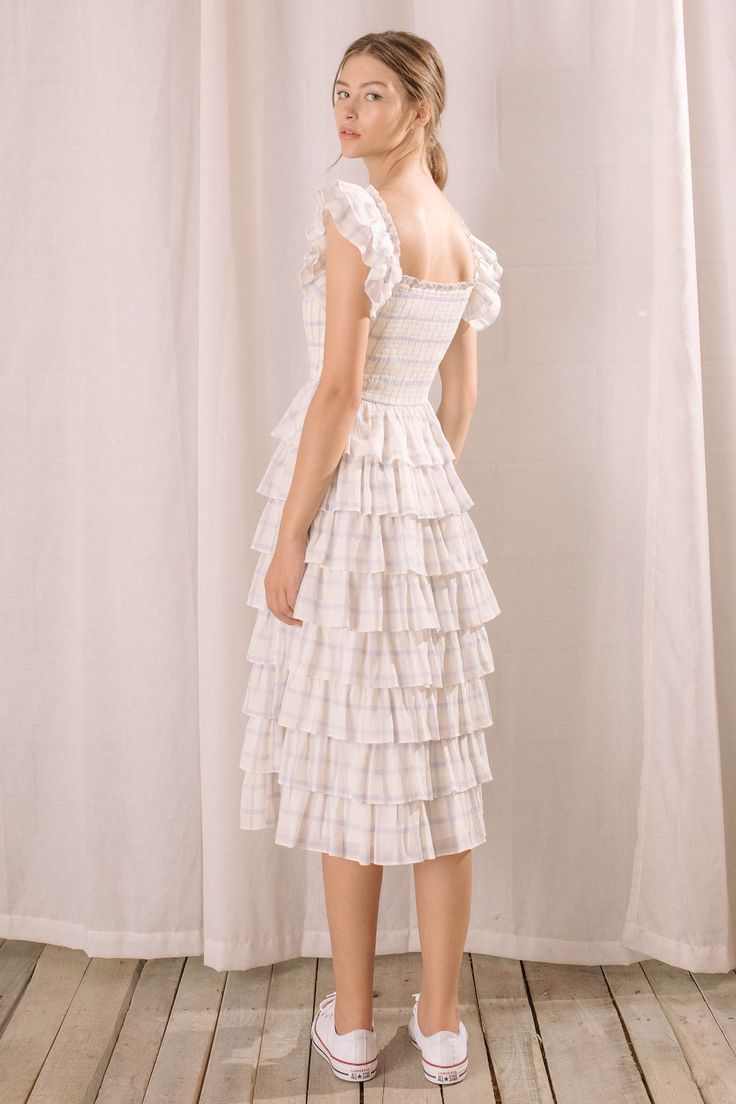 This gingham dress exudes cottage core and romantic elegance. It features a square neckline, smocked fitted upper body, and flounce and ruffled capped sleeves. Its tiered ruffles start at the waist and cascade to mid-length. Comfort and chic style come together to create the perfect look. Material:Polyester Cottagecore Square Neck Dress With Ruffle Hem, Cottagecore Tiered Skirt Dress With Ruffles, Ruffled Midi Prairie Dress For Daywear, Cottagecore Tiered Dress With Ruffles, Fitted Midi Prairie Dress With Ruffles, Midi-length Prairie Dress With Ruffles For Daywear, Midi Length Prairie Dress With Ruffles For Daywear, Fitted Midi-length Prairie Dress With Ruffles, Cottagecore Dresses With Ruffles And Tiered Skirt