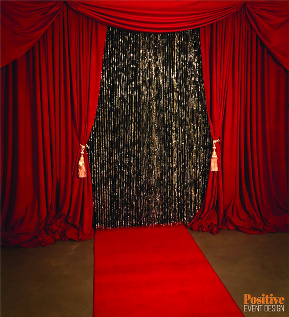 a red carpeted room with curtains and lights on the wall, and a red carpet in front of it