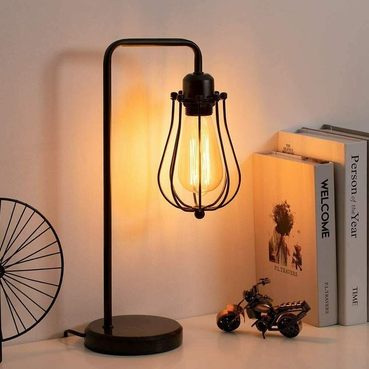 a lamp that is on top of a table next to some books and a bike