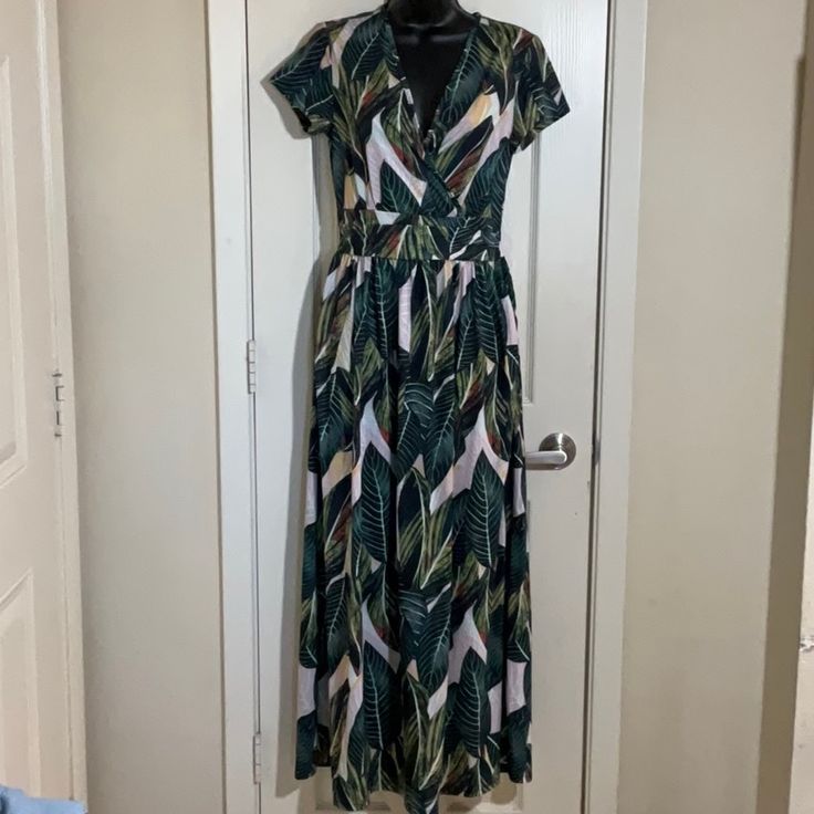 Beautiful Stretchy Tropical Print Dress Has Criss Cross Bust Area, Pockets On Both Sides And Zips On The Side, Armpit To Armpit 16”, Waist 26”, Length 54” Green V-neck Lined Maxi Dress, Flowy V-neck Maxi Dress With Tropical Print, Green V-neck Tropical Print Dress, Green V-neck Dress With Tropical Print, Summer Leaf Print Maxi Dress For Spring, Spring Leaf Print Maxi Dress, Leaf Print Maxi Dress For Spring And Summer, Green Tropical Print Short Sleeve Maxi Dress, Green Tropical Print Maxi Dress With Short Sleeves