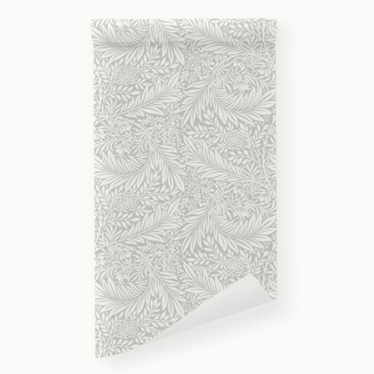 a white wall hanging on the side of a wall with a leaf pattern in it