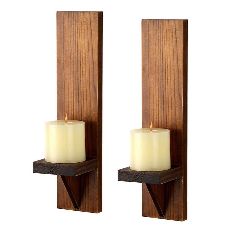 two candles are sitting on wooden shelves next to each other