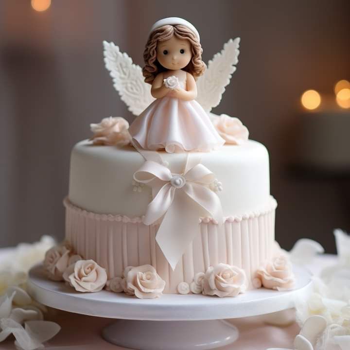 a wedding cake with an angel figurine on top and flowers around the edges