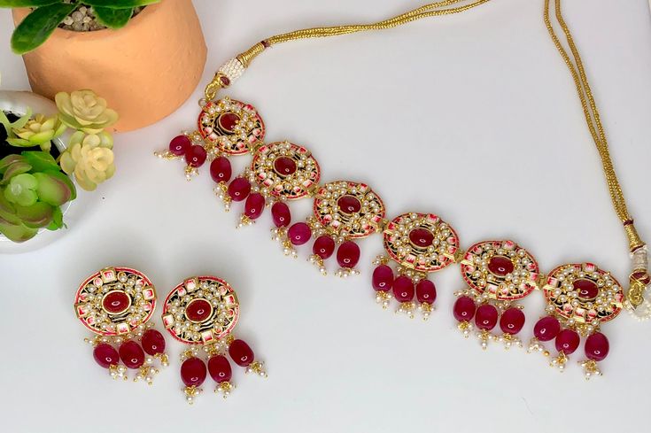 This necklace is a beautiful deep red color and is hand painted along with bright stones for an eye catching look. Comes with matching earrings to complete the look. Red Necklaces With Motifs For Festivals, Red Necklaces With Motifs For Gifts, Kundan Necklace With Motifs As Gift, Red Kundan Necklace For Festive Occasions, Red Chandbali Choker As Gift, Handmade Red Jewelry Sets For Festive Occasions, Red Choker For Festivals Gift, Handmade Red Kundan Necklace For Festivals, Red Chandbali Kundan Necklace For Festivals