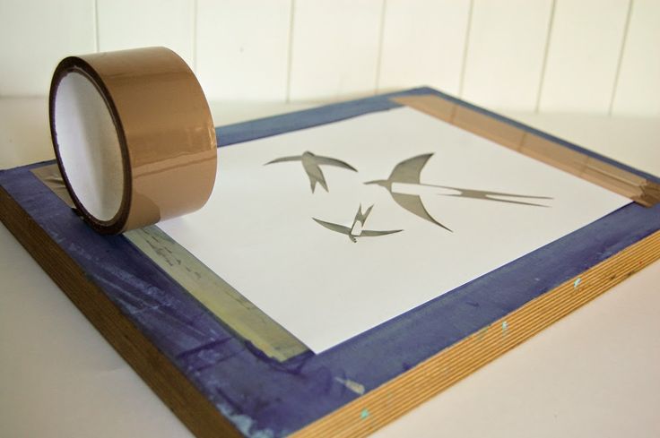 a roll of tape sitting on top of a piece of paper that has birds drawn on it