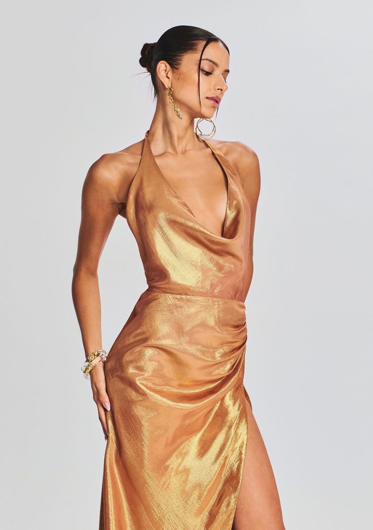 Dare to shine in our Cleo Dress. This cowl neck halter dress features a pleated detail at the hip and an ultra side slit. Shown here in Nude Glitter. 72% Silk, 28% Metallic Made in China Model is 5'10" wearing size S Style No. PF23-7060 Pre-draped Evening Dress With Cowl Back For Party, Halter Neck Cocktail Dress With Ruched Bodice, Chic Maxi Dress With Cowl Back For Party, Cocktail Dress With Ruched Bodice And Halter Neck, Cocktail Halter Neck Dress With Ruched Bodice, Pre-draped Halter Evening Dress, Ruched Cowl Back Gala Dress, Summer Party Halter Dress With Cowl Back, Chic Cocktail Maxi Dress With Cowl Neck