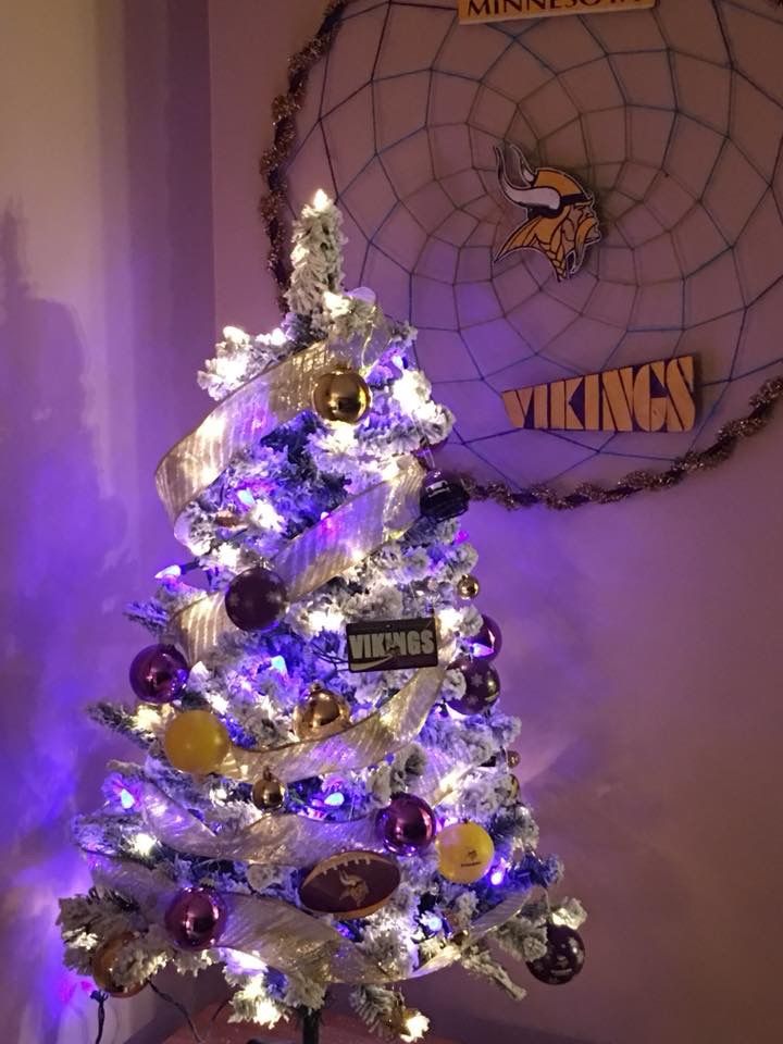 a purple and white christmas tree with minnesota license plates on it's top is lit up