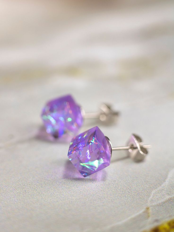 Purple Cube Earrings Dress up your ears with our mesmerizing Purple Cube Earrings! ✨ These statement studs are a celebration of modern elegance, carefully crafted to add a touch of glamour to any outfit. The iridescent allure of the resin material makes them the perfect choice for a Christmas gift or a thoughtful surprise for her. These stud earrings are not just accessories; they're a statement of individual style. Whether you're looking for everyday earrings or something special in purple, these colorful resin earrings fit the bill. Elevate your jewelry collection with these eye-catching cubes, a chic blend of sophistication and charm. 🎁👗 DETAILS - Fully handmade earrings - Made of epoxy resin and iridescent component - Zink clasp (silver is possible for the additional fee) - 8 - 10 mm Modern Purple Jewelry For Party, Modern Purple Earrings For Party, Purple Sterling Silver Earrings For Party, Cube Earrings, Resin Stud Earrings, Purple Resin, Halo Effect, Oc Stuff, 3d Cube