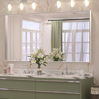 a bathroom vanity with two sinks and a large mirror above it, in front of a window