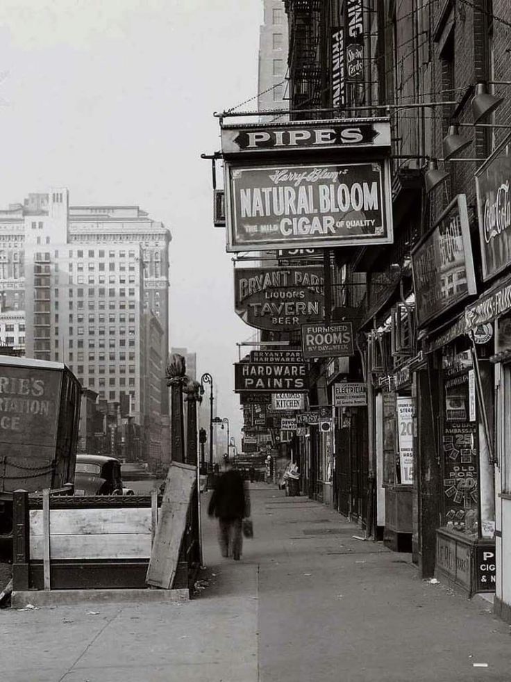 a man walking down a sidewalk next to tall buildings