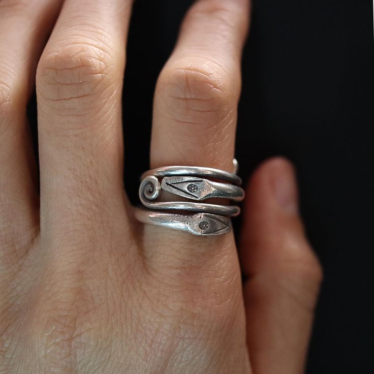 Discover the mystique of the Karen Silver Snake Wrap Ring. Handcrafted by skilled Karen artisans in Northern Thailand, this unique piece features a snake design that elegantly wraps around your finger. Made from high-quality Karen silver, renowned for its distinctive texture and craftsmanship, this ring embodies both tradition and modern style. Perfect for those who appreciate symbolic jewelry and the artistry of handmade creations. * Material: Premium 925 sterling silver, ensuring durability an Artisan Sterling Silver Ring With Unique Design, Artisan Open Ring With Unique Design, Symbolic Hand Forged Sterling Silver Rings, Spiral Sterling Silver Promise Ring, Artistic Sterling Silver Open Ring, Unique Silver Snake Ring For Promise, Handmade Sterling Silver Open Snake Ring, Unique Silver Open Snake Ring, Unique Sterling Silver Open Snake Ring